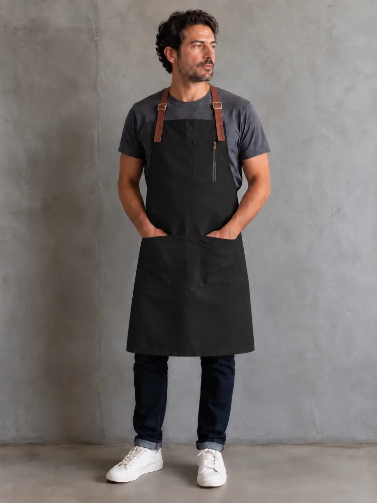 Delantal gastronómico negro de gabardina con tirantes de cuero para restaurante y cafetería